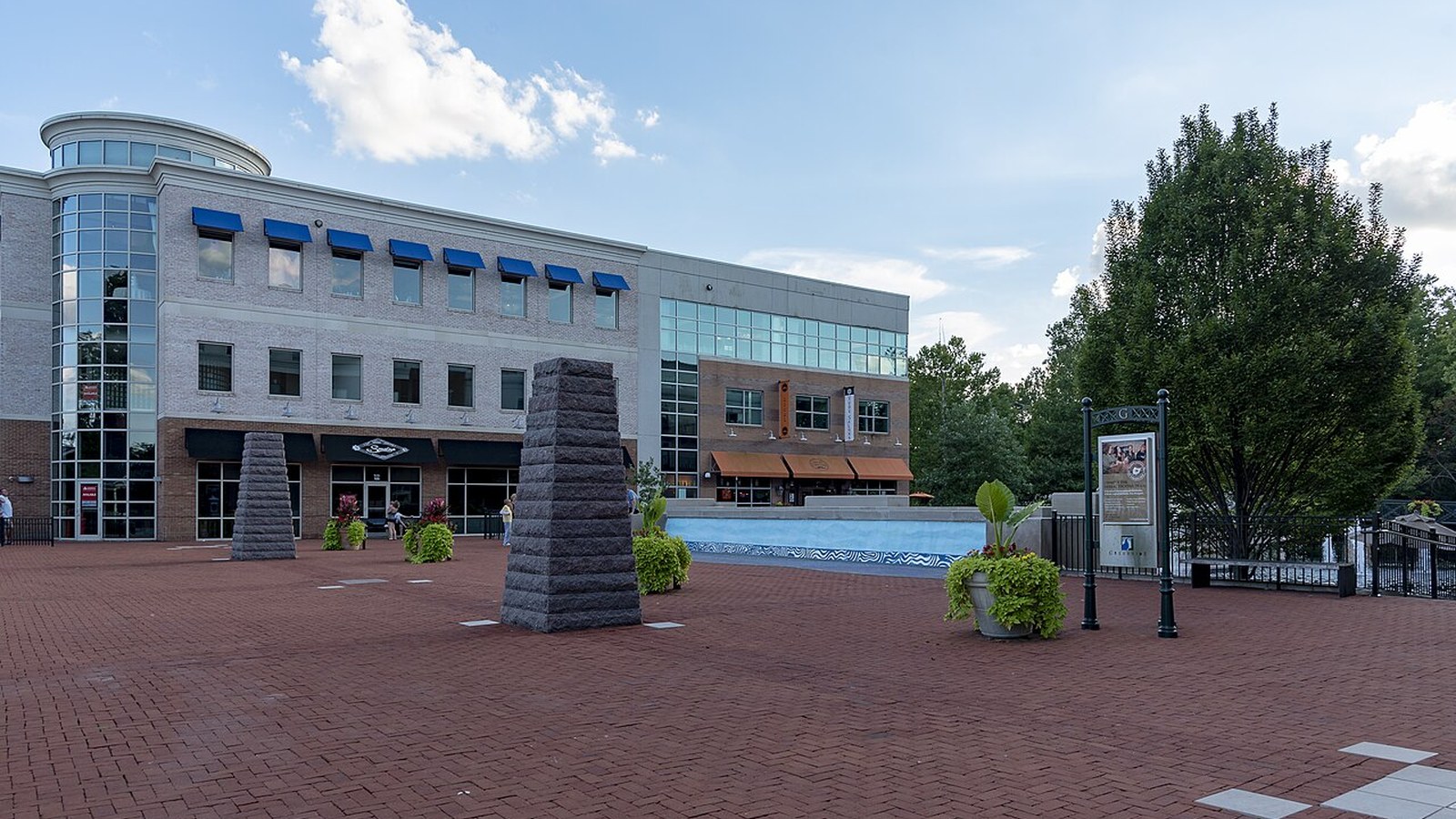 The entrance plaza to Creekside Gahanna from Mill Street, with its glass-fronted building and fountain