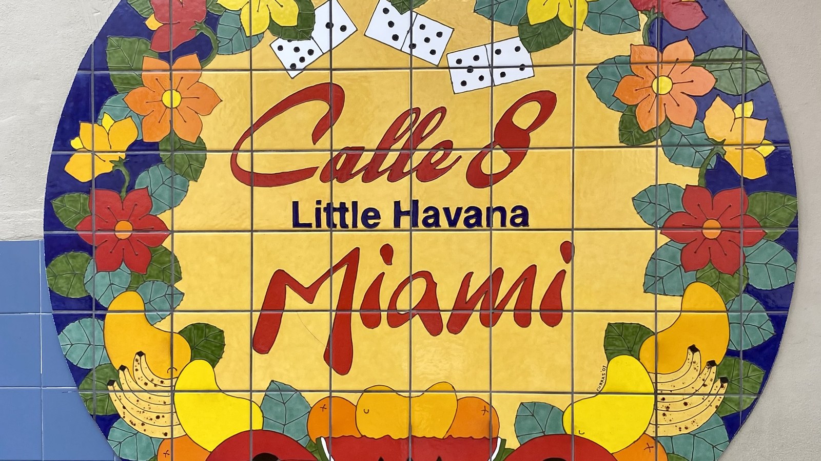 A colorful hand-painted tile mural reading 