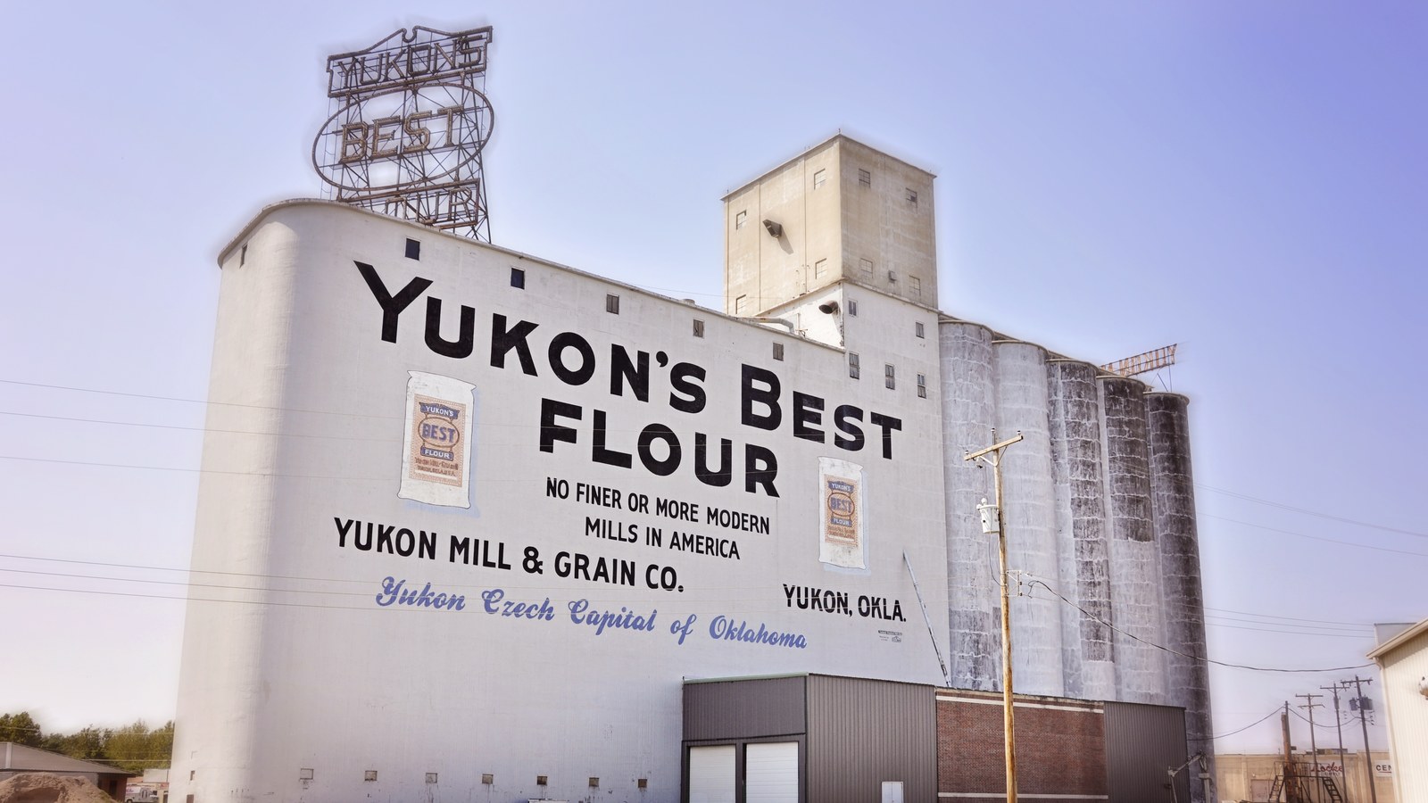 The landmark Yukon's Best Flour Mill grain elevator on historic Route 66, with its rooftop neon sign and painted mural
