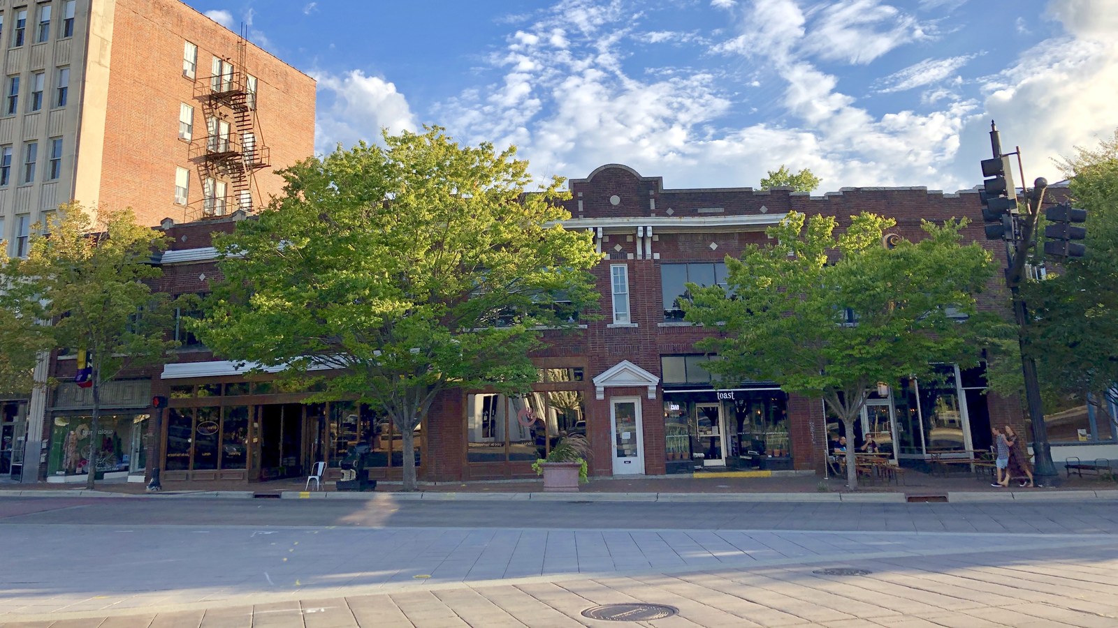 Brick storefronts at the corner of Chapel Hill Street and Main Street in Downtown Durham, with pedestrians on the sidewalk