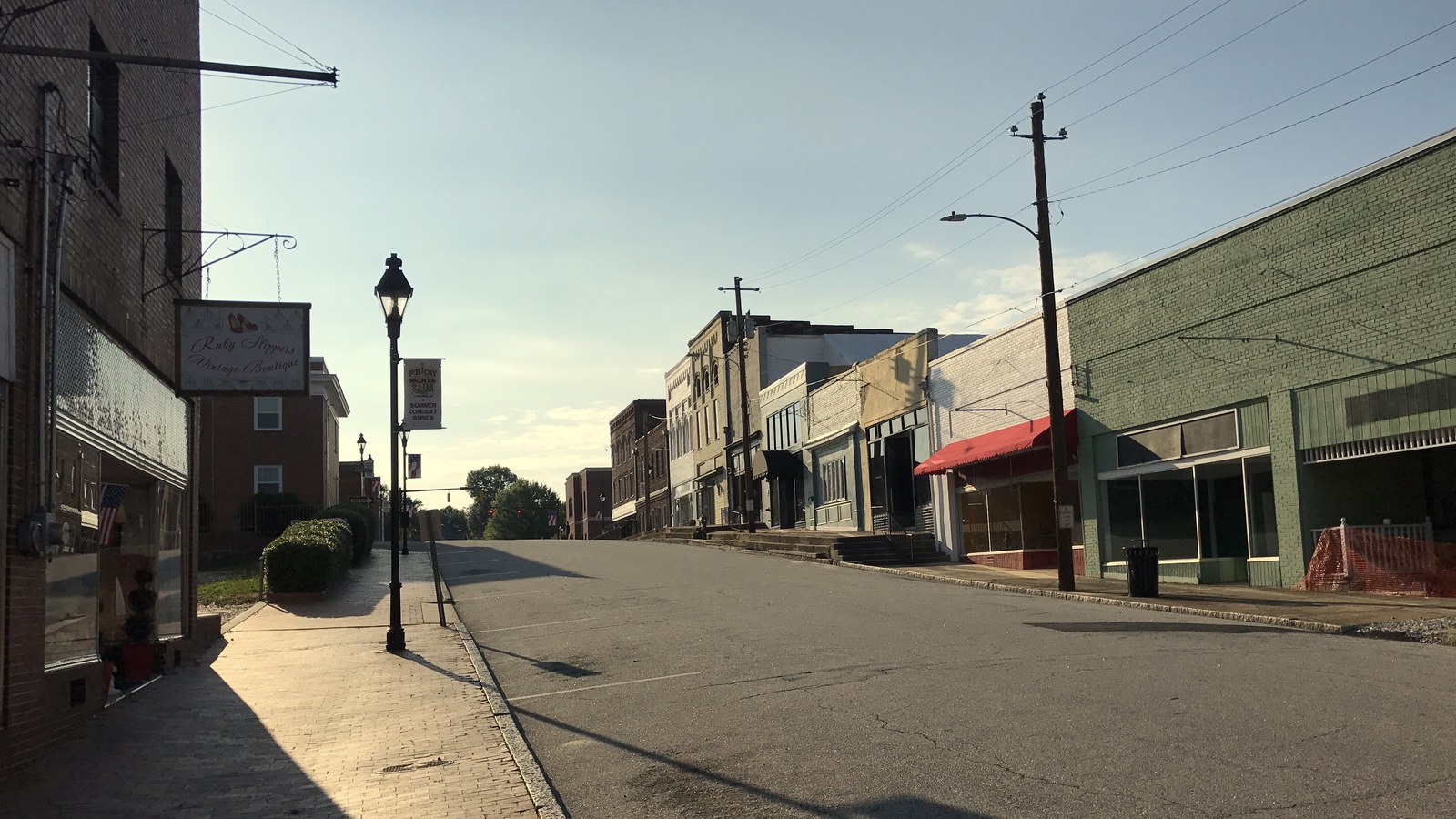 Nash Street in downtown Louisburg, lined with brick storefronts in warm late-afternoon light