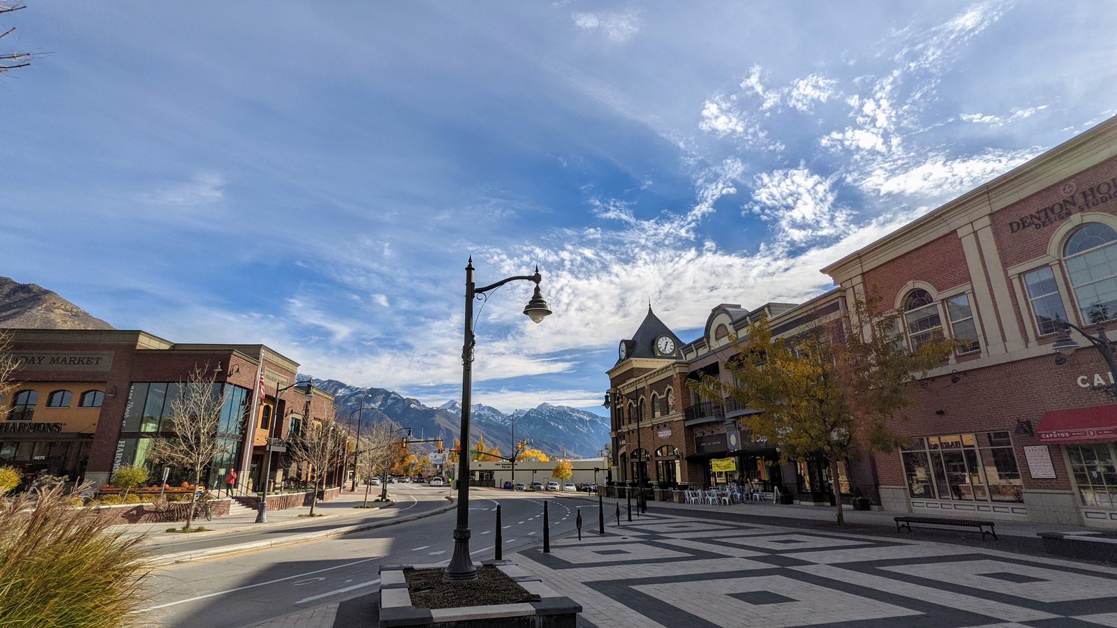 Downtown Holladay Village in Holladay, Utah, with brick storefronts, a clock tower, and the Wasatch Range rising behind Main Street